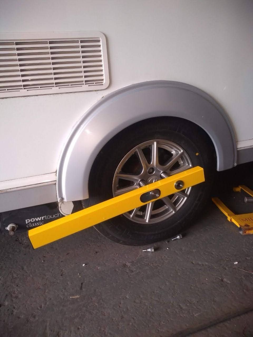 Caravan wheel secured with the yellow KLUNK wheel lock