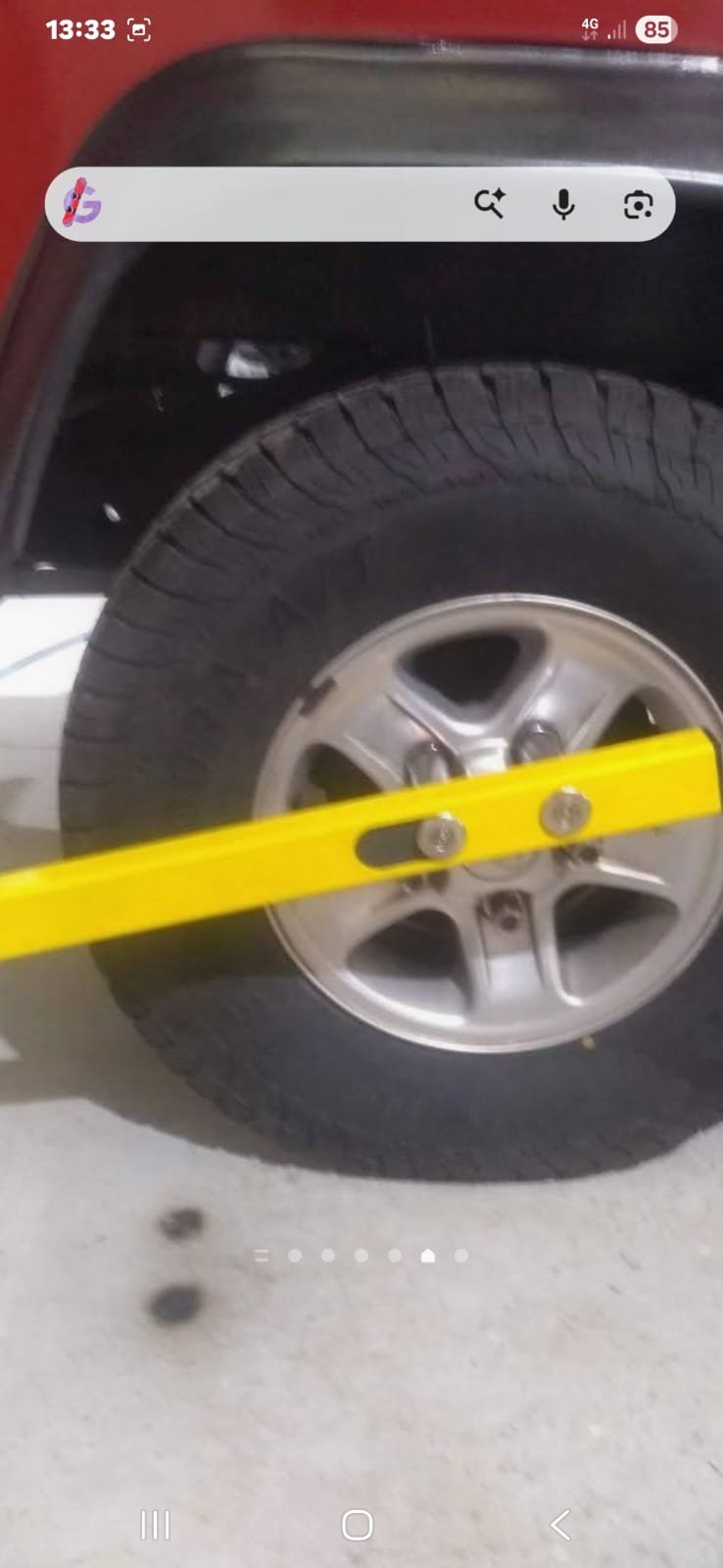 Yellow KLUNK fitted to a red Defender wheel — close-up
