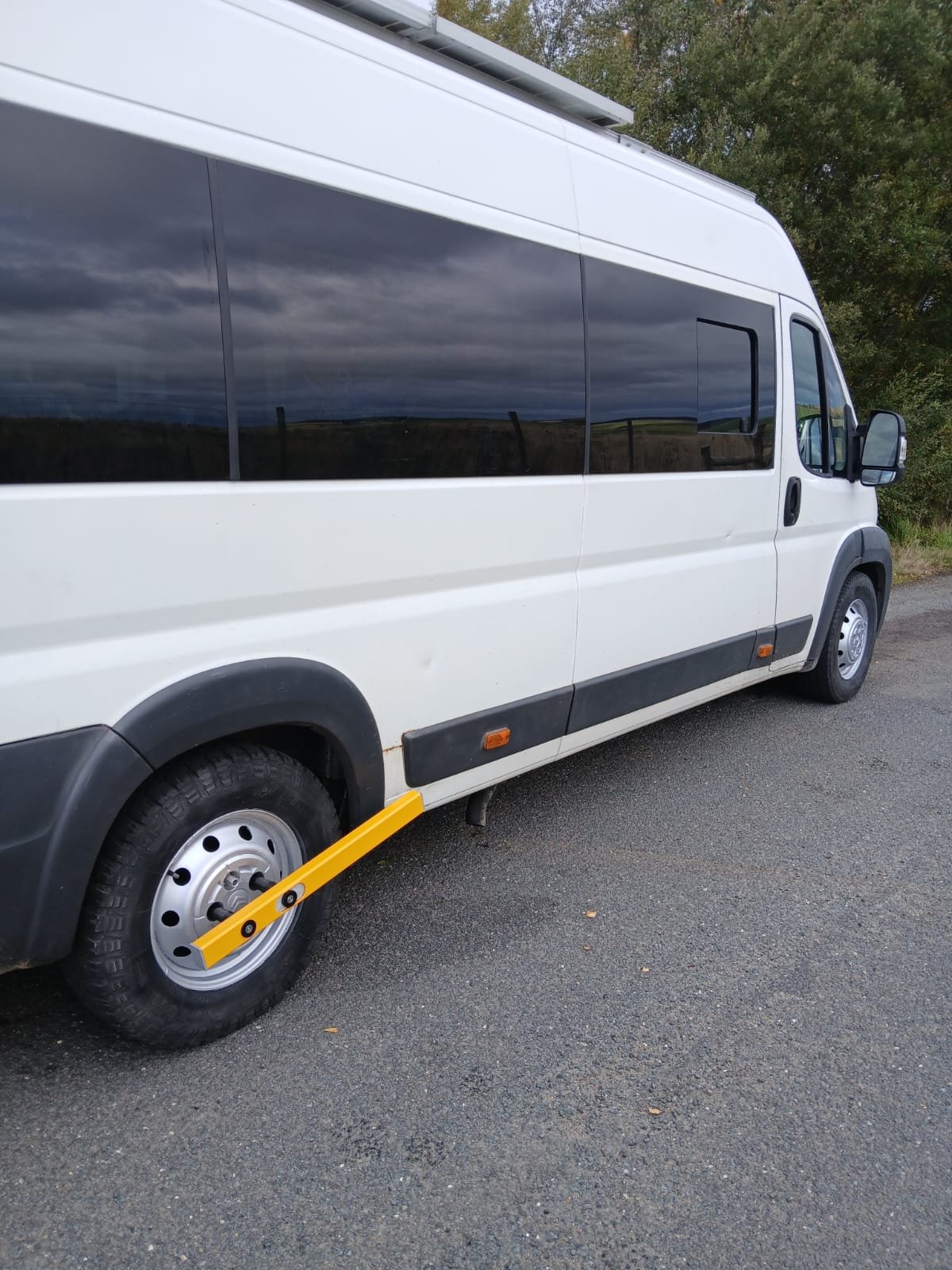 White minibus van secured with the yellow KLUNK wheel lock